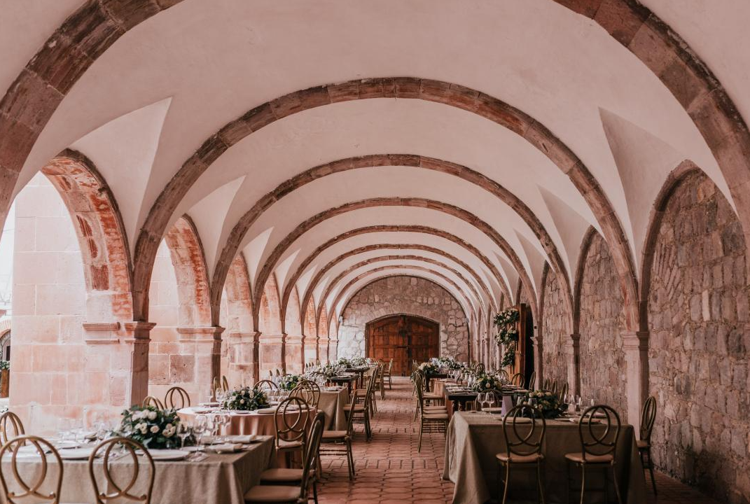 Interior de Finca Santa con arcos de piedra y mesas preparadas para la recepción